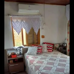 Quarto com janela e cortinas brancas em um imóvel em Lajeado.