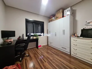 Sala de estar com piso de madeira e armários brancos em um imóvel no Brasil.