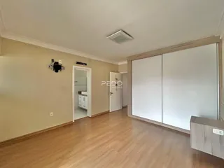 Hall de entrada com piso de madeira clara e portas brancas.