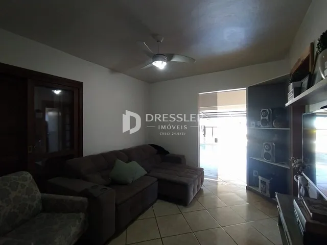 Sala de estar com sofá e piso de cerâmica em um imóvel no Brasil.