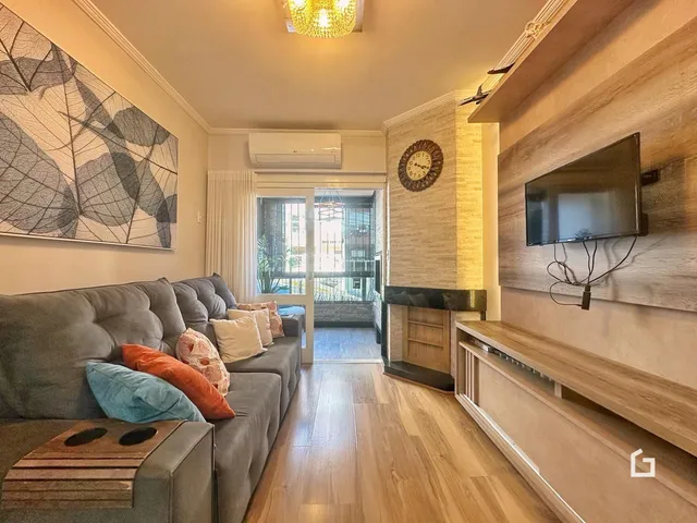 Foto da sala de estar com sofá e piso de madeira.