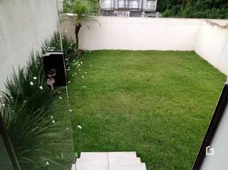 Gramado externo com muro branco.