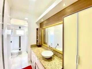 Foto de um banheiro com bancada de mármore e revestimento branco.