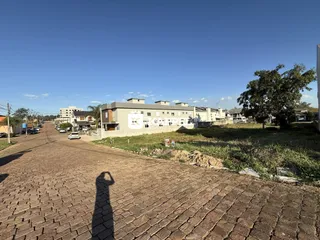 Vista externa de uma rua pavimentada em Lajeado, Brasil, mostrando edifícios residenciais ao fundo.