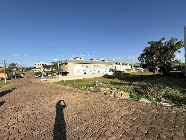 Vista externa de uma rua pavimentada em Lajeado, Brasil, mostrando edifícios residenciais ao fundo.