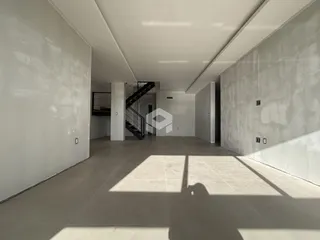 Vista de um corredor interno com paredes brancas e piso de cerâmica.