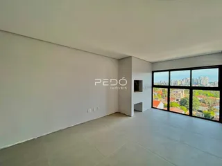 Interior de uma sala ampla com paredes brancas e piso claro.