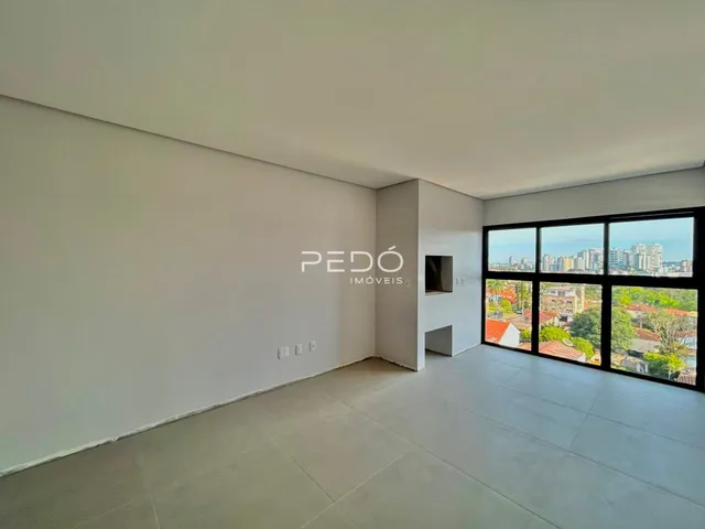 Interior de uma sala ampla com paredes brancas e piso claro.