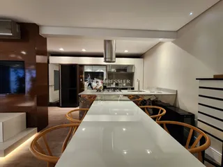 Vista da cozinha moderna com ilha e armários em Lajeado.
