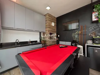 Cozinha moderna com armários cinzas e mesa de pingue-pongue.