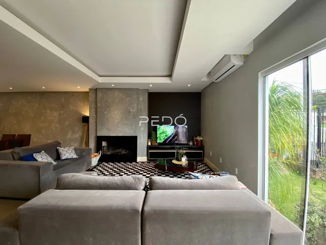 Sala de estar moderna com lareira e grande janela de vidro.