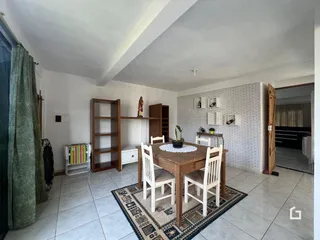 Foto de uma sala de jantar com mesa de madeira e piso cerâmico.
