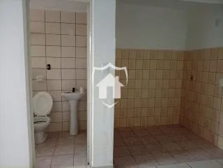 Banheiro com azulejos brancos e louças instaladas.