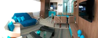 Sala de estar com sofá azul e painel de madeira em um imóvel.