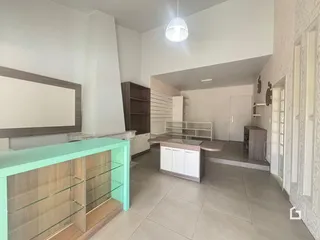 Ambiente interno de uma sala de estar com piso de cerâmica e armários de madeira.