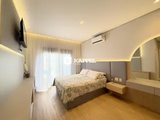 Quarto com cama e cortinas brancas em um ambiente bem iluminado.