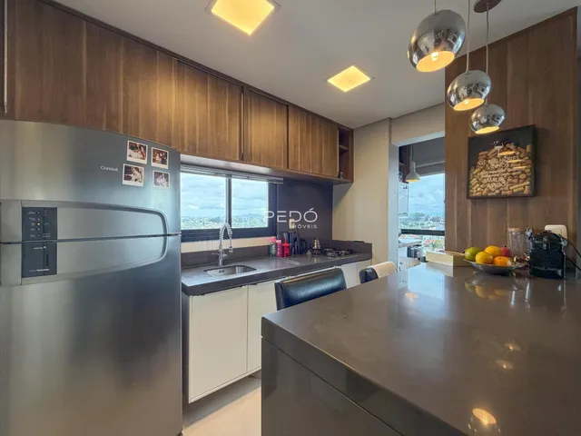 Vista da cozinha com armários de madeira e eletrodomésticos de aço inoxidável.
