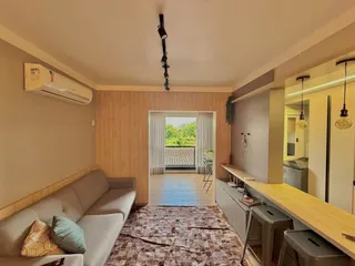 Foto de uma sala de estar com sofá e painel de madeira.