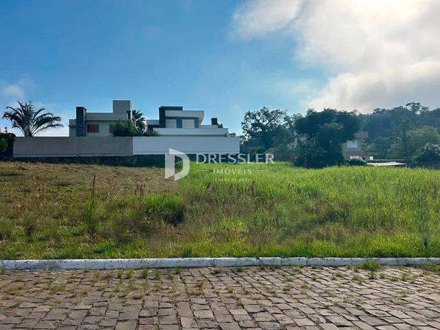 Vista externa de uma casa moderna em Lajeado, Brasil, com jardim gramado à frente.