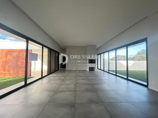 Vista interna de um ambiente moderno com grandes janelas de vidro.