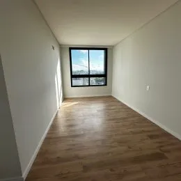 Foto de um corredor com piso de madeira clara e paredes brancas.