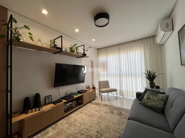 Sala de estar moderna com decoração de prateleiras e sofá cinza.