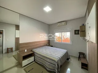 Quarto com cama e cabeceira de madeira em um imóvel no Brasil.