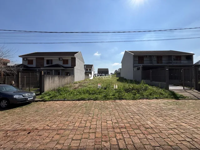Vista externa de duas casas em Lajeado, Brasil, com jardim e cerca.