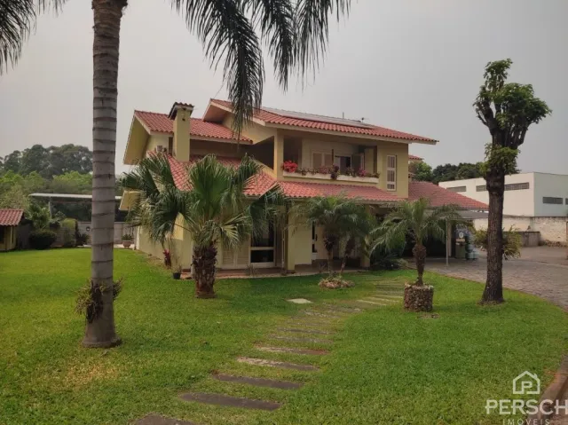 Fachada de uma casa residencial em Lajeado, Brasil, com paisagismo verde.