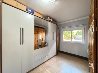 Quarto com armários embutidos e janela na parede.
