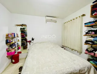 Quarto com cama grande e armários de roupas no interior de uma residência.