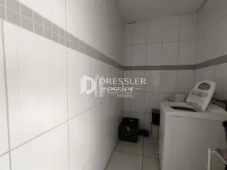 Parede interna com revestimento de cerâmica branca em um imóvel.