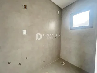 Foto do interior de um espaço com paredes de concreto em Lajeado.