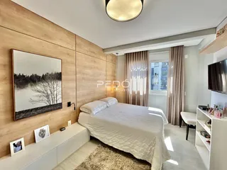 Quarto com cama e painel de madeira na parede.