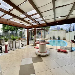 Vista de uma área externa com piscina e jardim.
