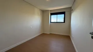 Vista de um corredor com piso de madeira e janela em um imóvel.