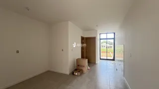 Interior de um ambiente com piso de cerâmica e parede branca.
