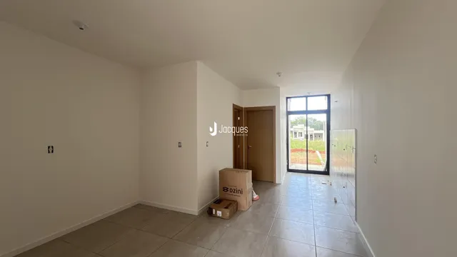 Interior de um ambiente com piso de cerâmica e parede branca.