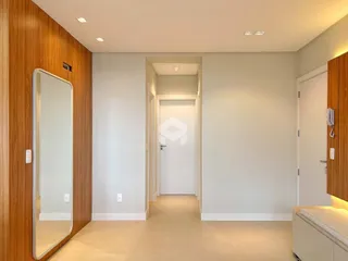 Hall de entrada com parede de madeira e espelho.