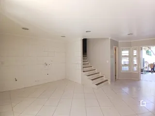 Ambiente interno amplo com piso de cerâmica e paredes brancas.