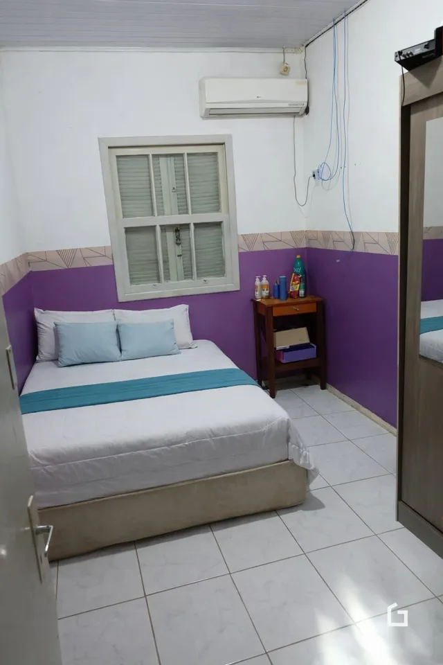 Quarto com cama e janela em uma residência.
