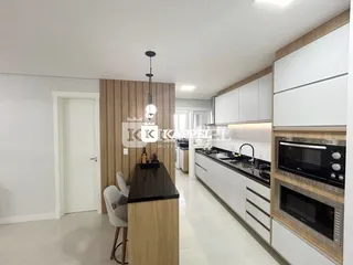 Foto de uma cozinha moderna com armários brancos e bancada escura.
