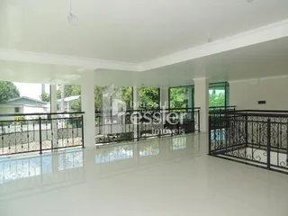 Sala de estar ampla com piso claro e vista para o exterior.