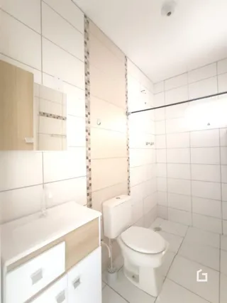 Foto de um banheiro com revestimento branco e vaso sanitário.