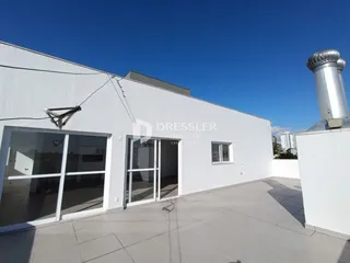Fachada branca de uma residência em Lajeado, Brasil, com portas de vidro e área externa.