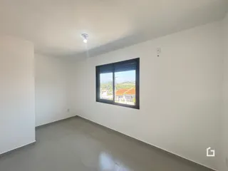 Ambiente interno de uma sala com grande janela voltada para a paisagem.