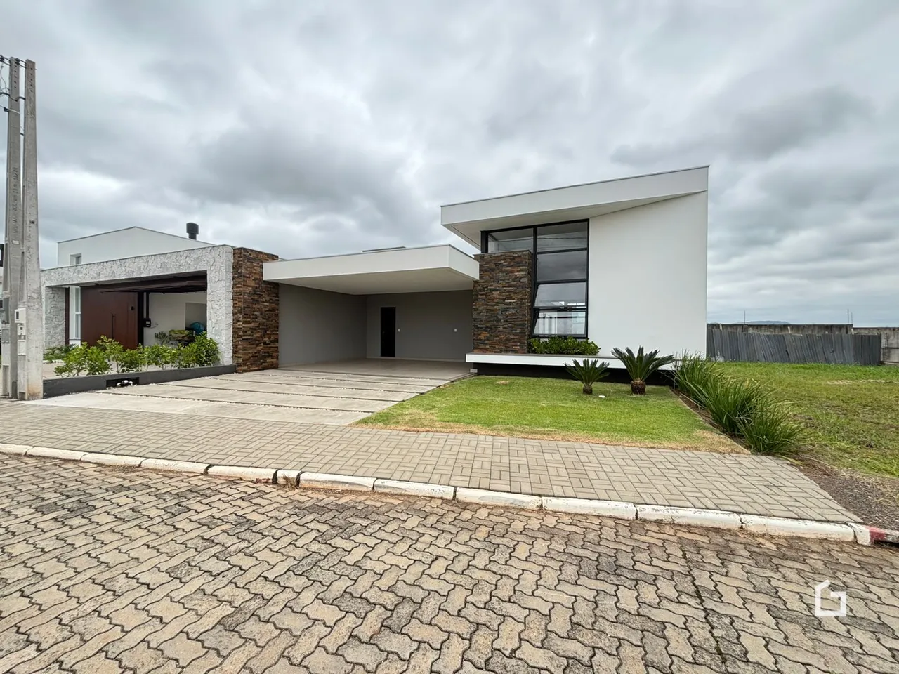 Fachada moderna de uma residência em Lajeado, Brasil, com área externa pavimentada.
