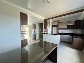 Imagem de uma sala de estar moderna com cozinha integrada.