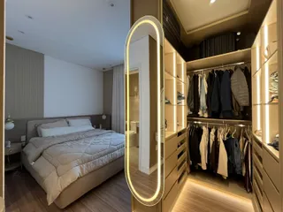 Quarto com cama grande e armário embutido com iluminação em LED.