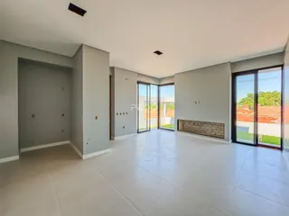 Esta é uma foto de um ambiente interno amplo com piso claro e portas de vidro.